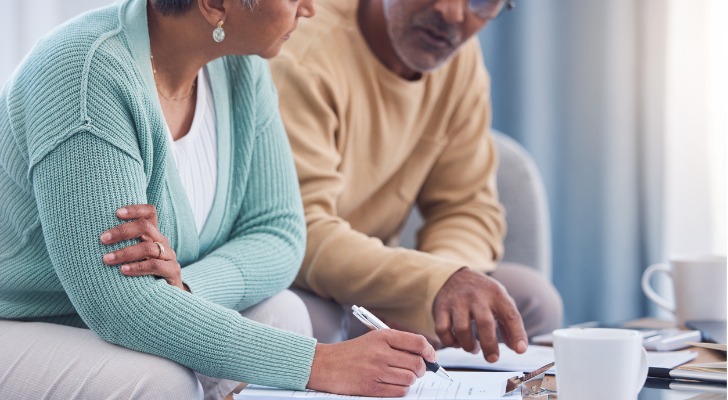 A married couple looks over their will together.