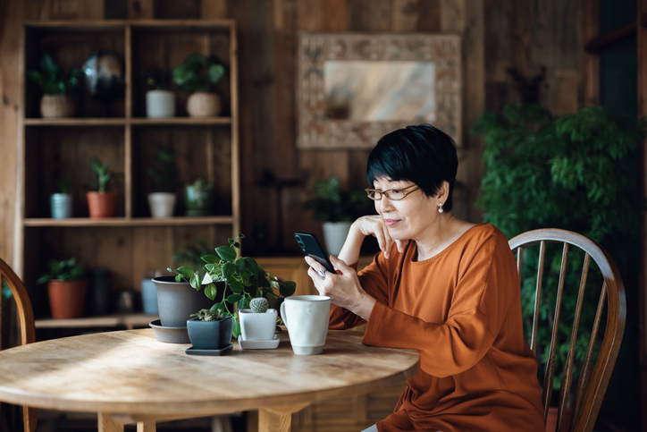 A woman looks over her monthly finances using a budgeting app on her phone.