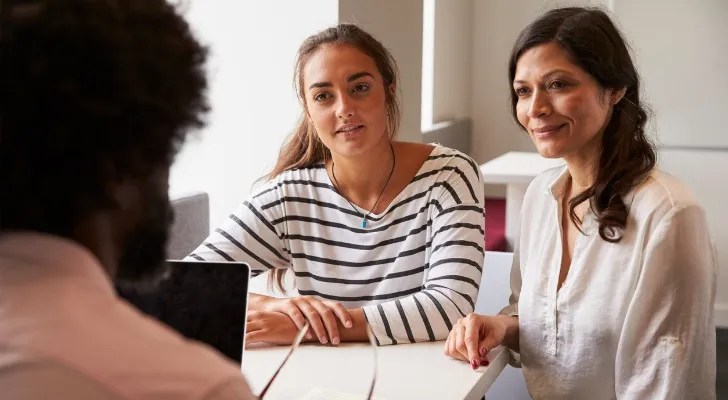 A mother and daughter meet with a financial advisor to review college savings plan options.