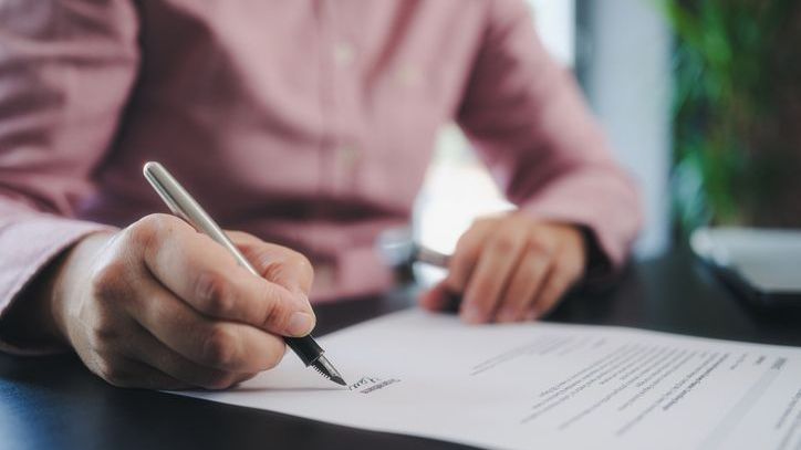 A man signs documents establishing a living trust in Colorado so he can avoid the probate process.