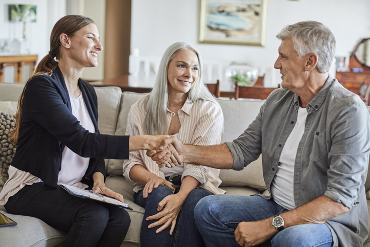 A senior couple meets with a financial advisor to discuss an estate plan that includes a will and a trust in North Carolina.