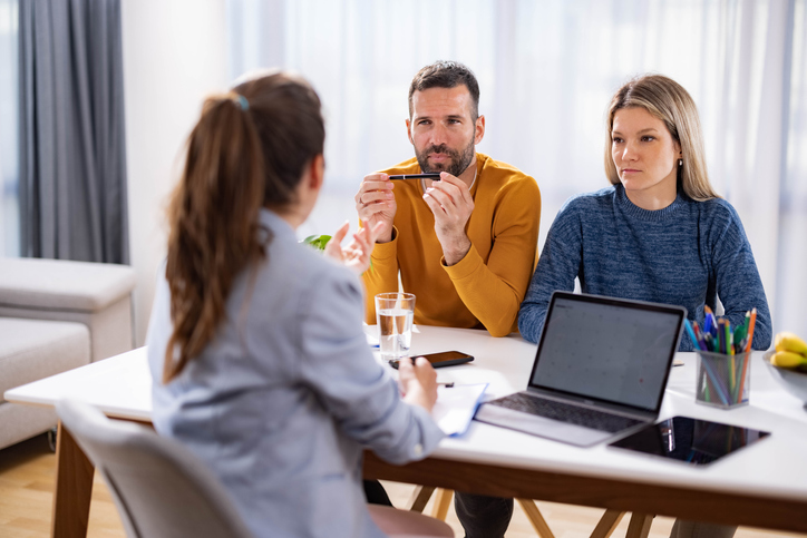 A financial advisor with a financial psychology certification helping a couple manage their financial habits.