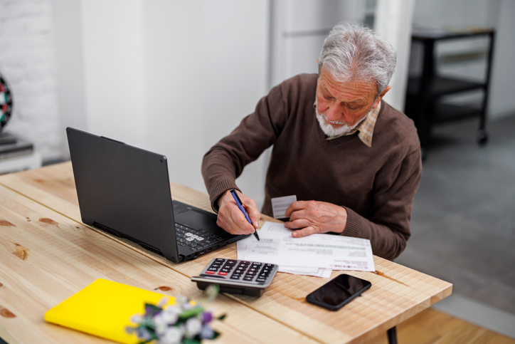 A senior calculating how much he will owe in RMD taxes.