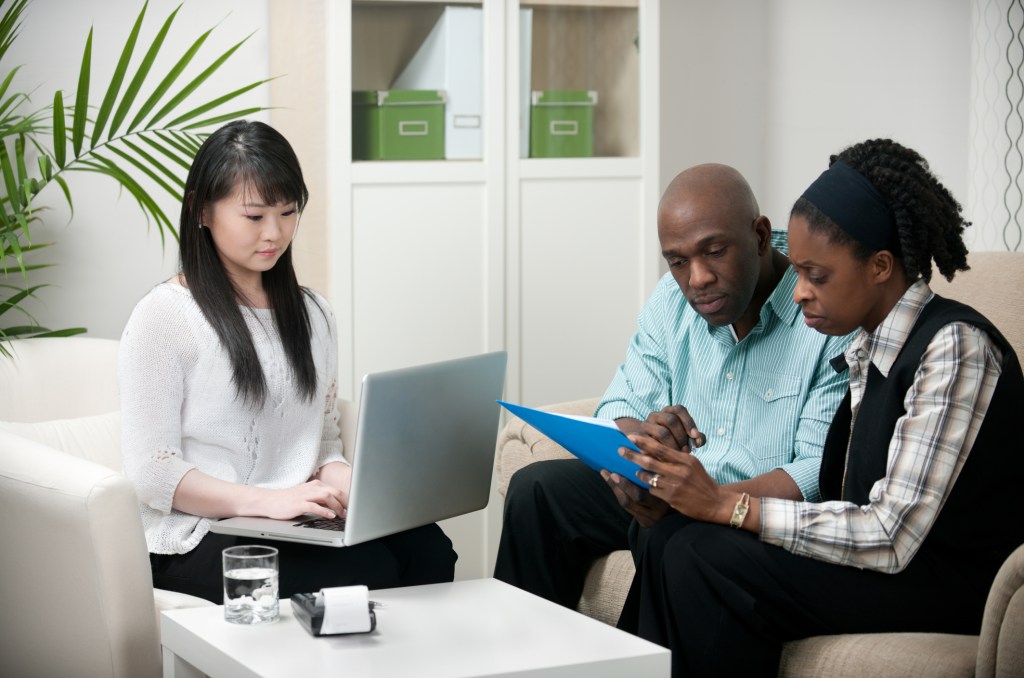 An investment manager meeting with a couple to help them rebalance their portfolio.