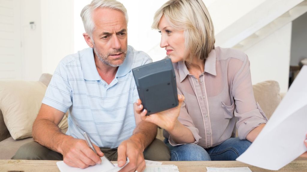 A couple does some math on a calculator to determine if they should switch to Roth contributions or complete a Roth conversion.