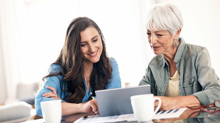 A woman looks at a home on her tablet with her mother, who has offered to help her pay for the purchase.