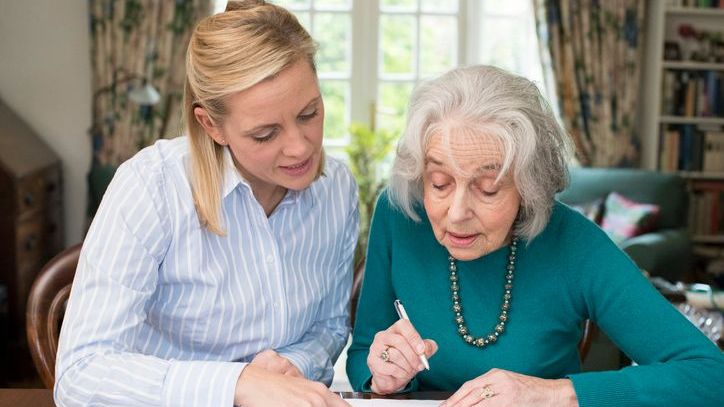 A woman signs a document giving her daughter medical power of attorney.