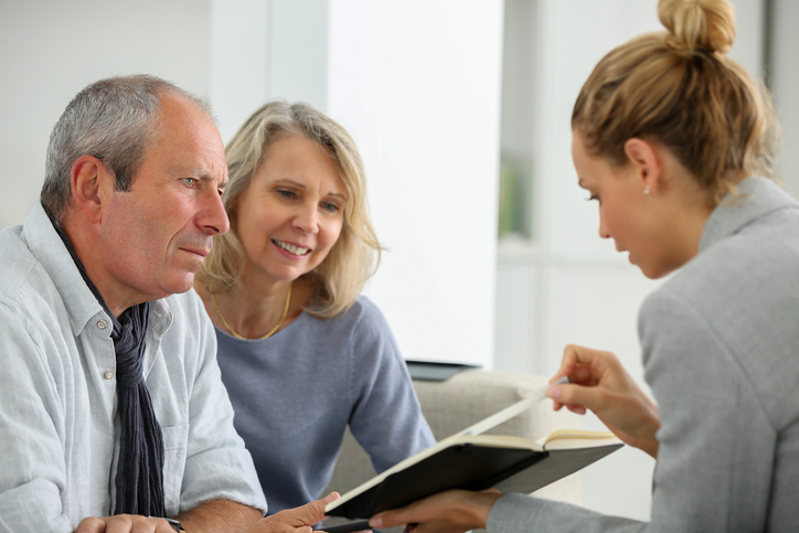A couple reviewing their retirement plan with an advisor as they approach retirement.