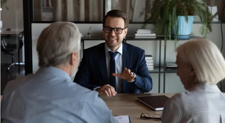 An estate planner meets with a pair of prospective clients who saw his digital marketing materials online.