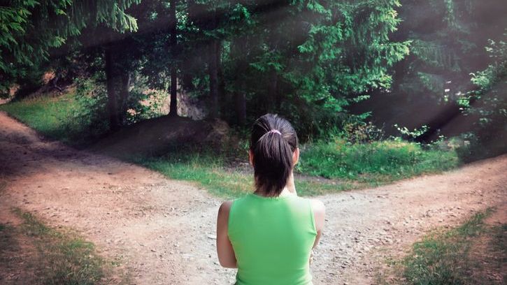 A hiker reaches a fork in the trail and decides which path to take.