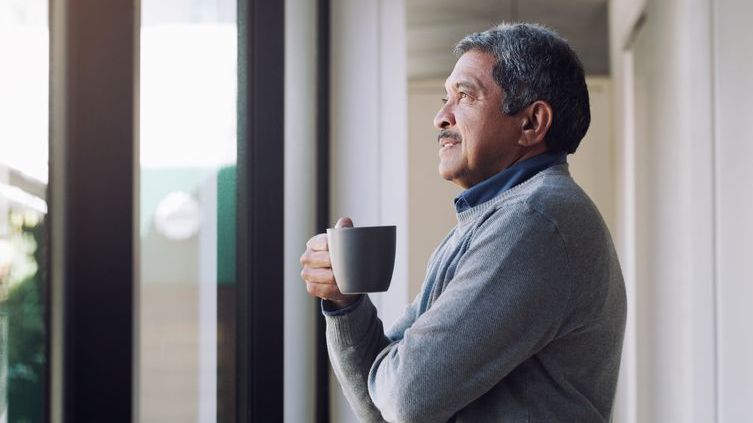 A retirement business owner relaxes with a cup of coffee.