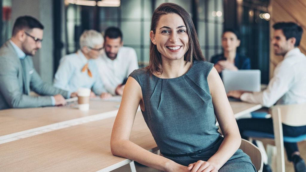 A financial advisor smiles during a staff meeting at her new RIA firm.