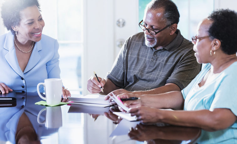 A senior couple meeting with a financial advisor in Florida to review their estate plan.