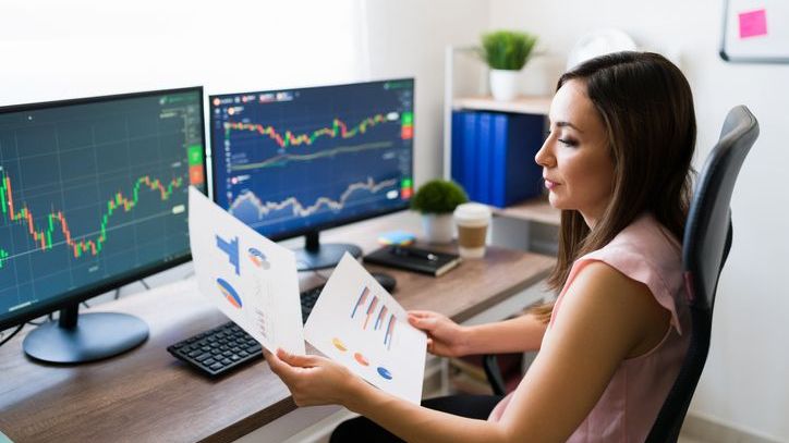 A financial analyst tracks the performance of several exchange-traded products on the computers in her office.