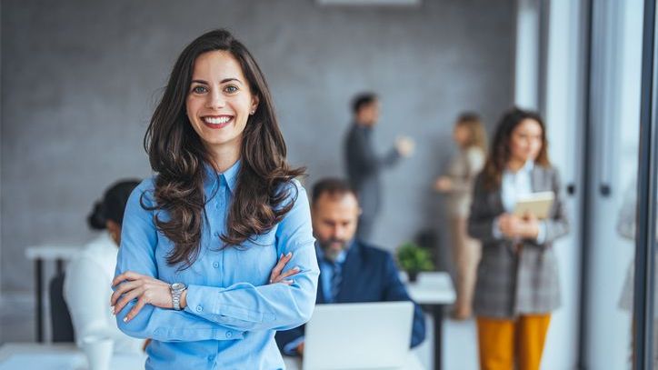 A financial advisor who holds the chartered financial consultant (ChFC) designation stands while colleagues meet in the background.
