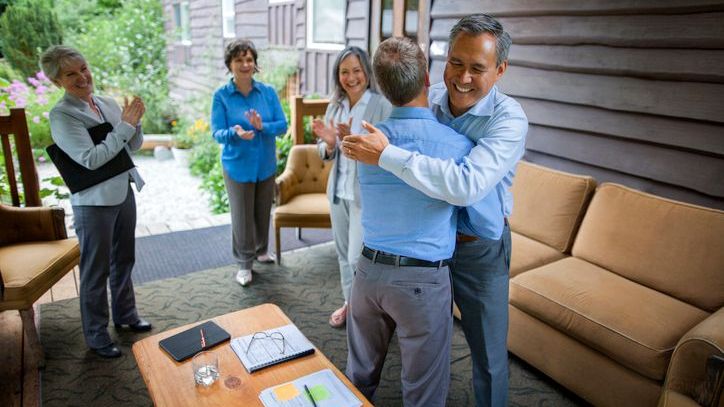 A retiring business owner congratulates the successor he chose to run the business.