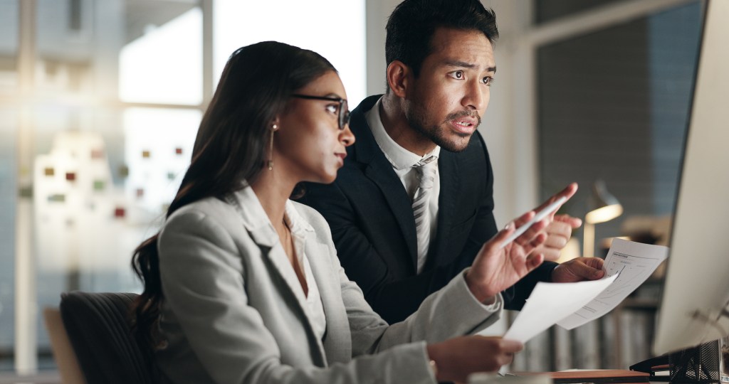 Financial advisors reviewing a list of questions for clients.