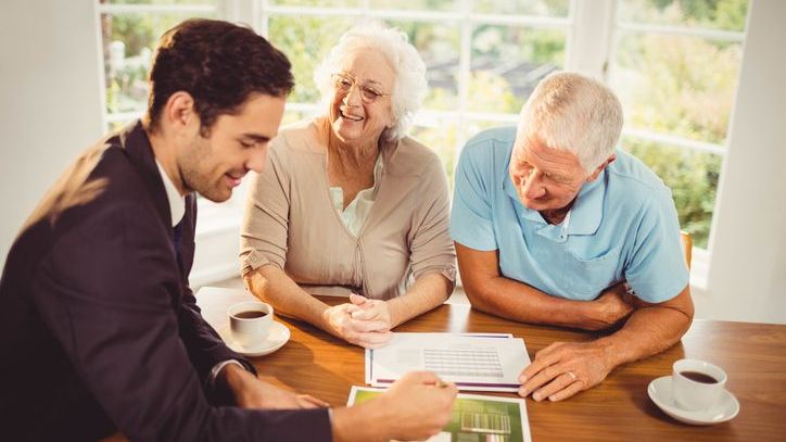A financial advisor meets with two clients who are in their 70s.