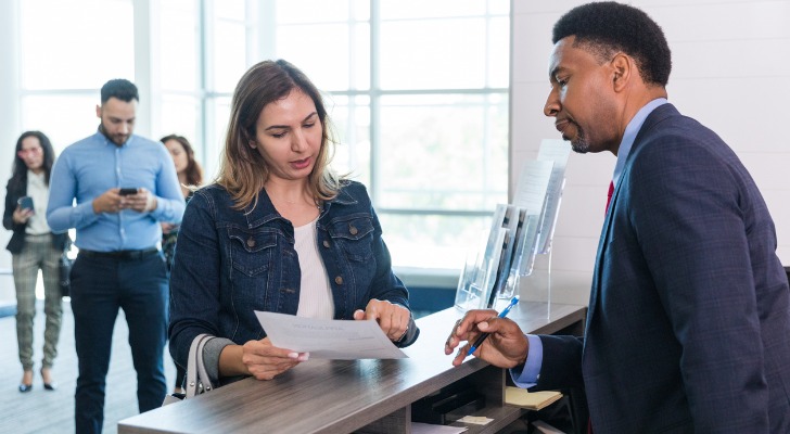 A woman presents a form at her bank.