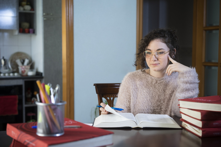 A woman thinking about repaying her student loans.