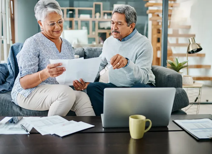 A couple preparing documents for a personal transaction with a cashier's check.