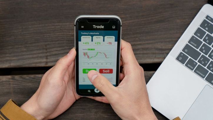 An investor buys a stock on his phone using fractional shares.