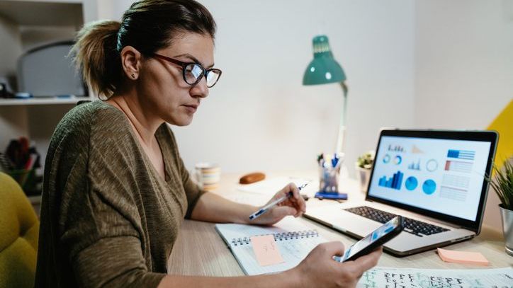 An investor looks over her investment portfolio on her phone.