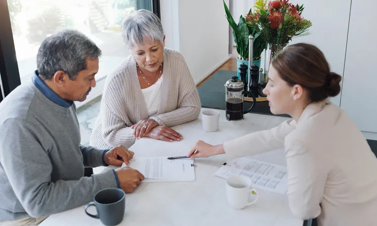 A senior couple reviewing documents for a real estate deal that will require a cashier's check.