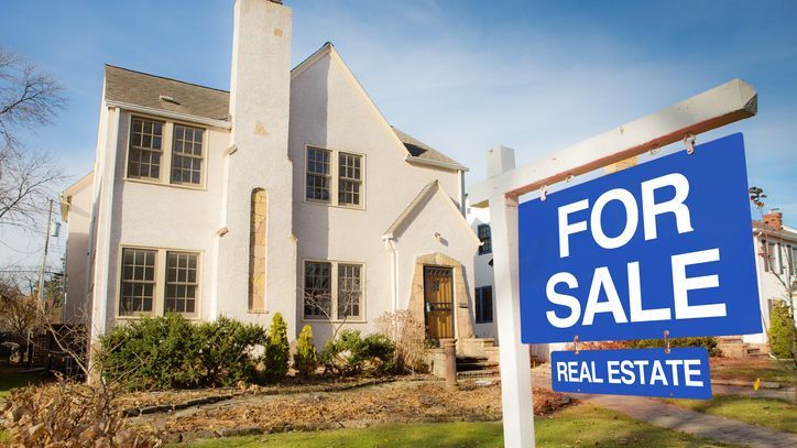 A for sale sign hangs in front of the home of a divorcing couple.