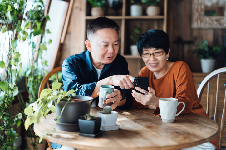 A senior couple looking up the returns on their investments.