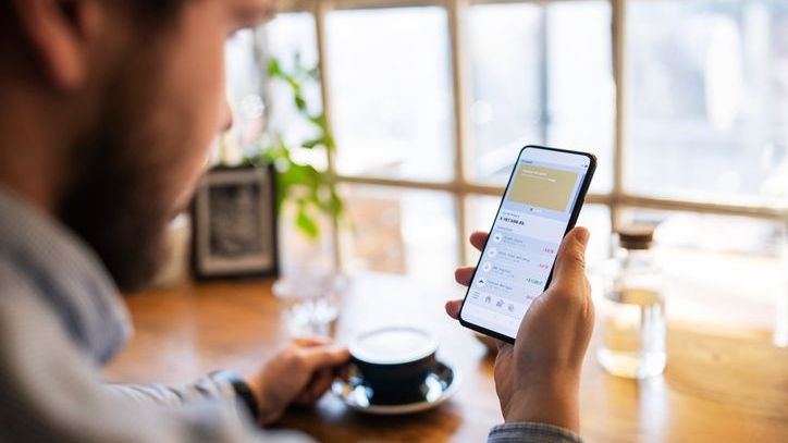 A bank customer looks at his money market account balance on his phone.