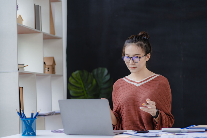 A woman comparing IBR vs. SAVE student loan repayment options.