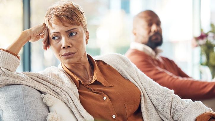 A woman looks away from her husband, while they talk about getting a divorce.