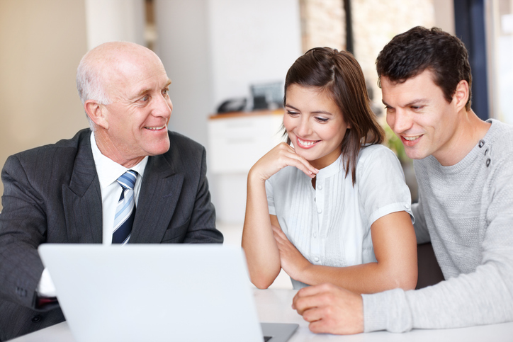 A couple meeting with a financial advisor to strategize the best ways to safeguard their portfolio from inflation.