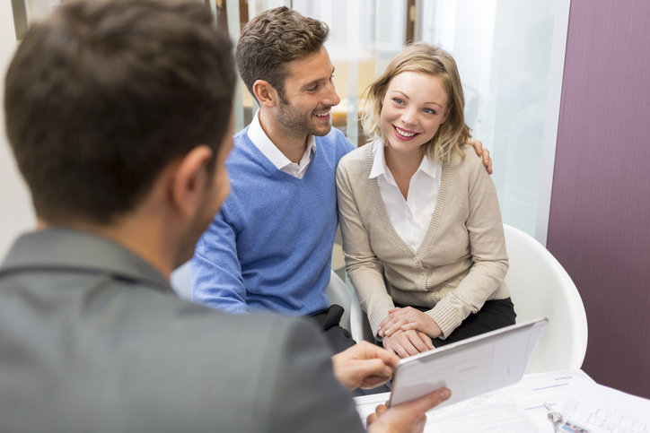A couple meeting with an advisor to diversify their investment portfolio with traditional and speculative investments.