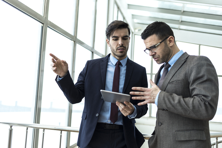 Two financial advisors discussing how to improve their sales process.