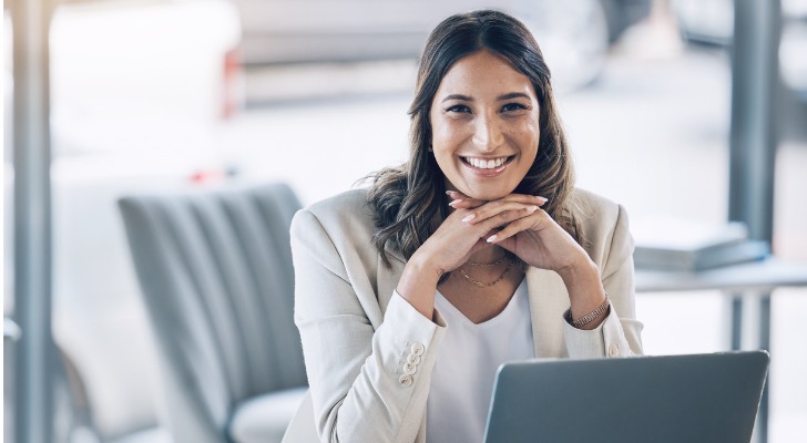 A financial advisor who holds the certified personal finance counselor (CPFC) credential smiles from behind her desk.