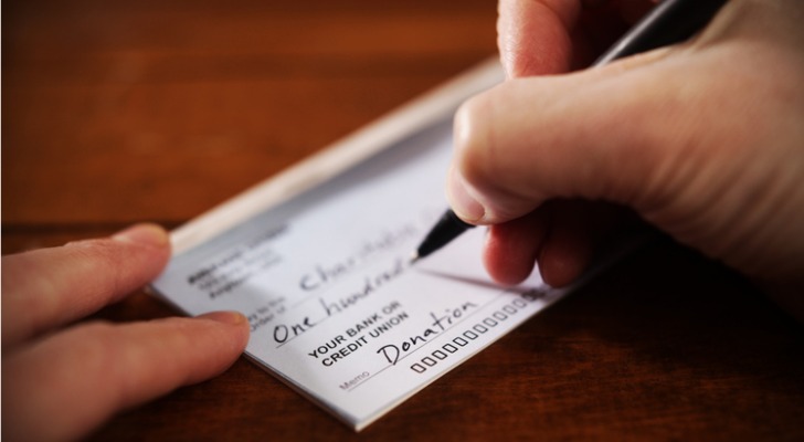 A wealthy donor writes a check to a charity.