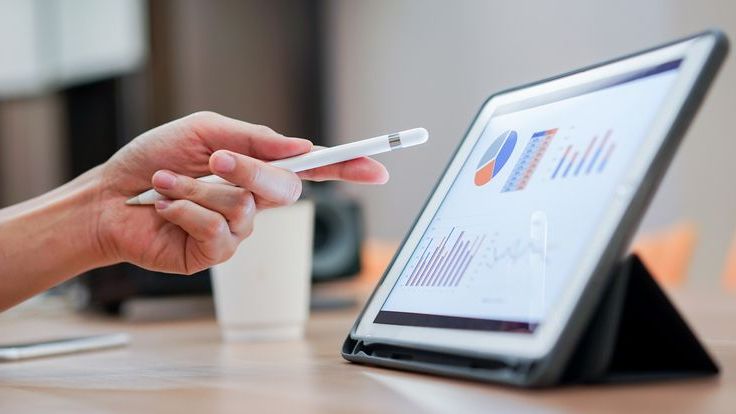 An investor looks at their portfolio's asset allocation on a tablet and considers how to rebalance their holdings.