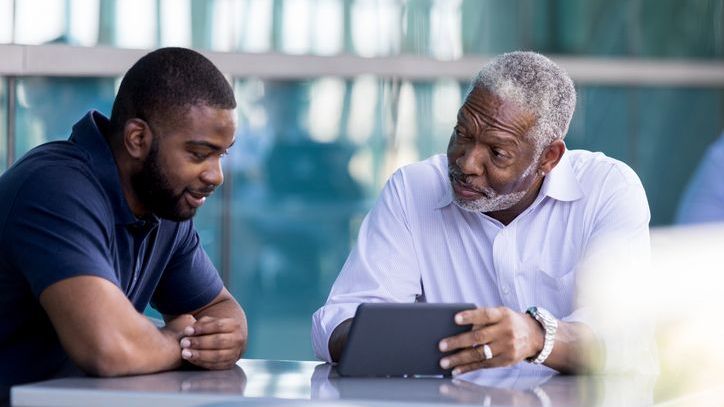 A man reviews his will with his son.