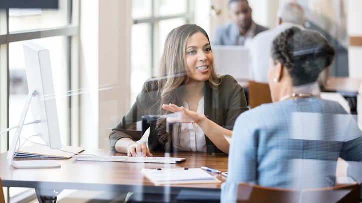 A credit union employee meets with a member to talk about her deposit accounts.