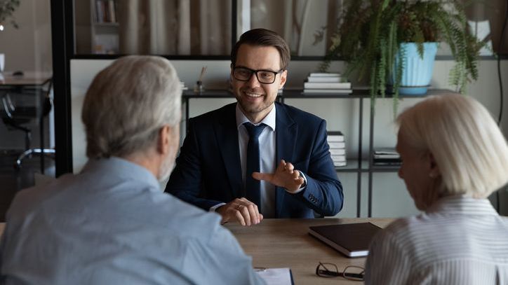 A fiduciary financial advisor meets with clients to talk about the selection of a trustee for their trust.