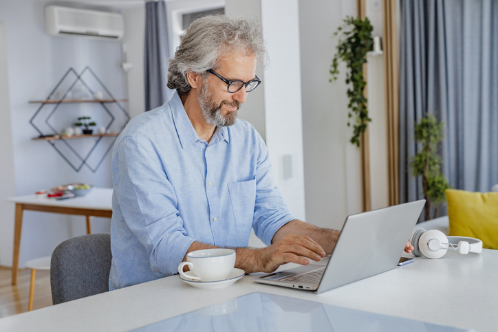 A man looking up the benefits of saving in an IRA over a 401(k).