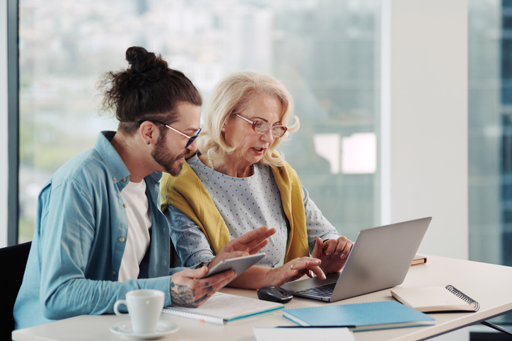 A senior researching with her grandson the differences between a rollover IRA and a Roth IRA.