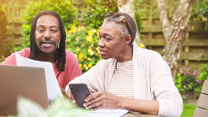 A married couple looks over their will while sitting in the backyard of their Denver home.