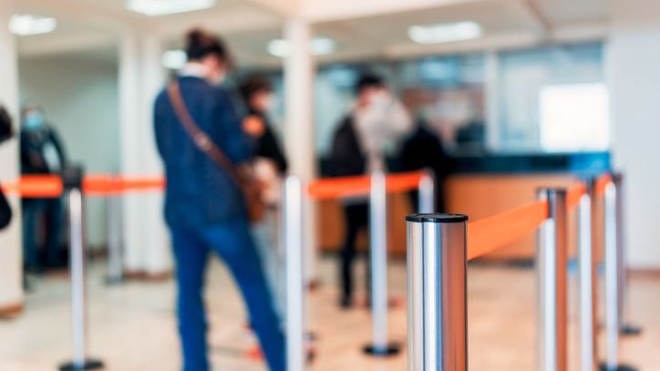 Members of a credit union wait in line for a teller.