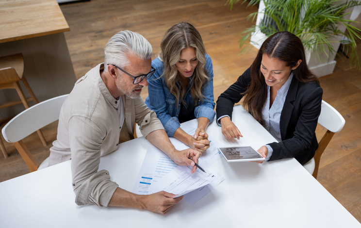 Ultra high net worth clients reviewing preferential rates on loans and other financial products with a private bank manager.