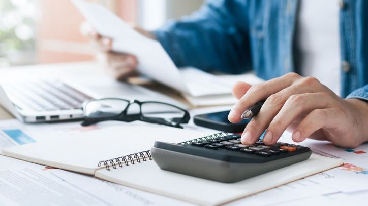 A man calculates his capital gains while working on his tax return.