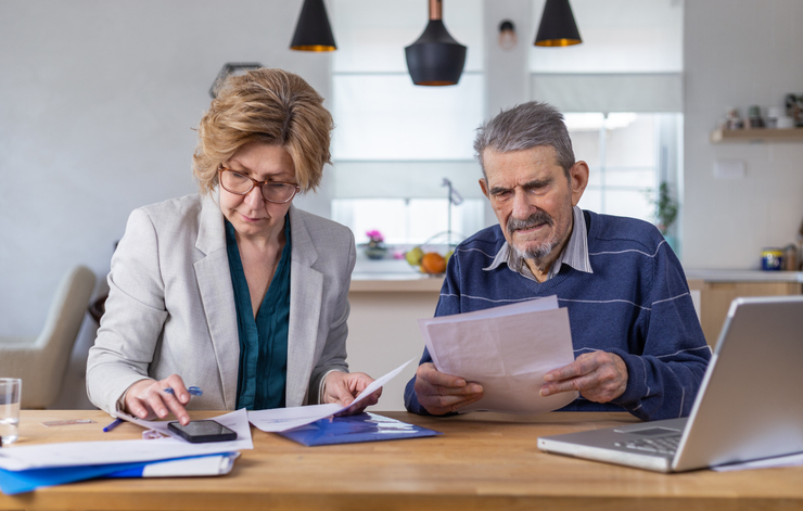A husband and wife drafting power of attorney documents to close a bank account.