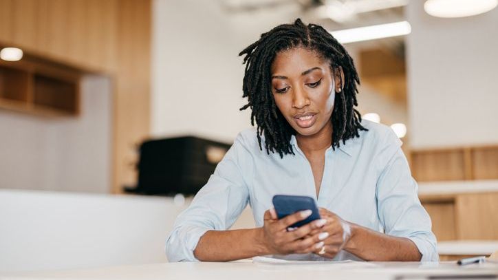 A woman looks over her portfolio and considers selling certain investments to rebalance her asset allocation.